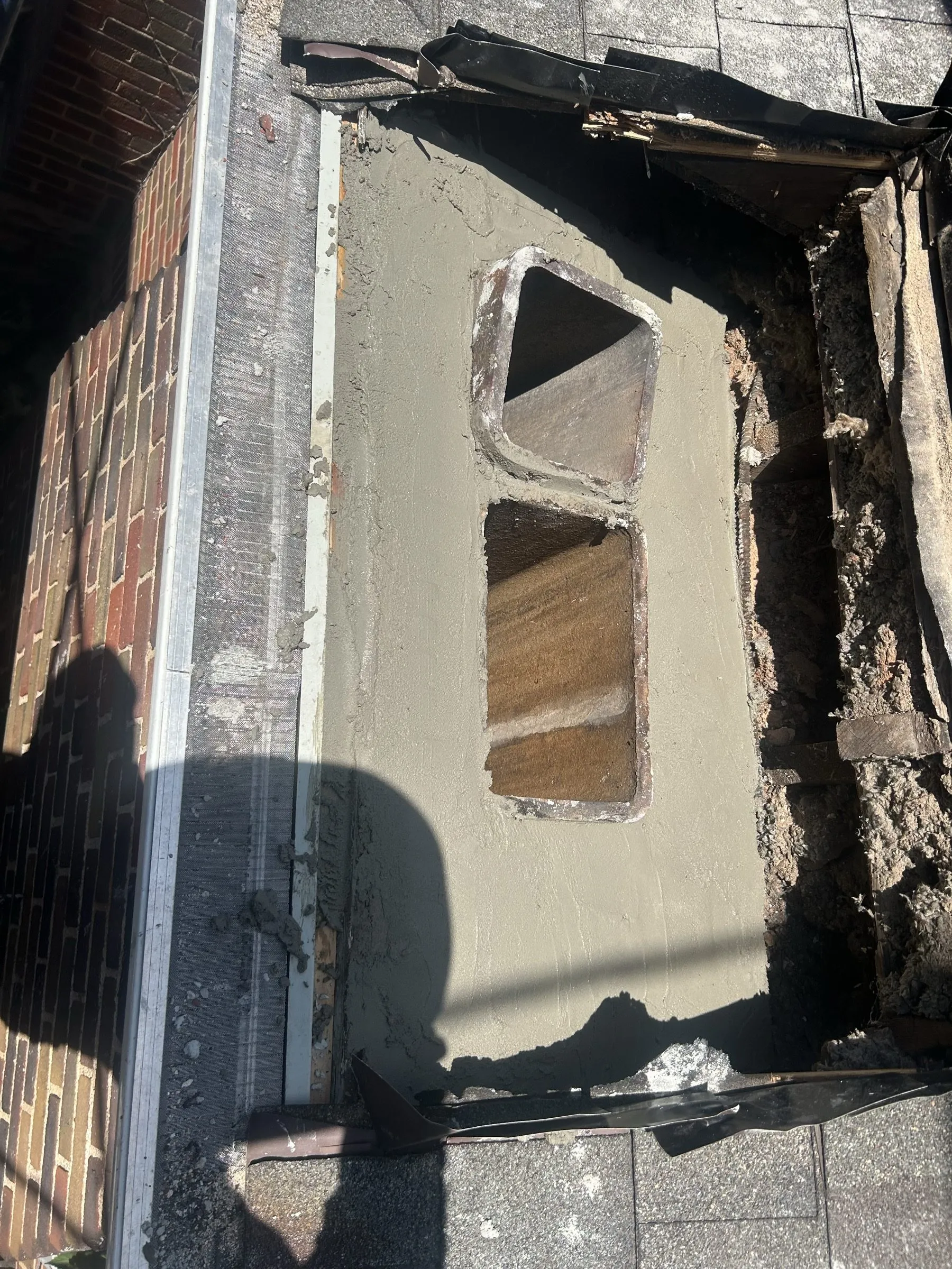 The roof opened around the chimney base, a new reinforced pad cast with two flue openings.