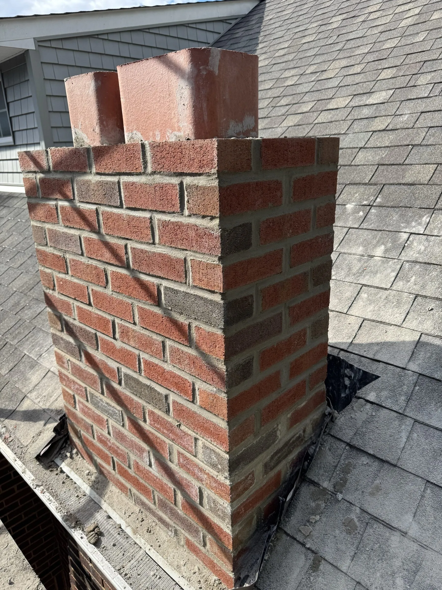 Close view of the new brick coursing and the flashing worked in tight against the shingles.