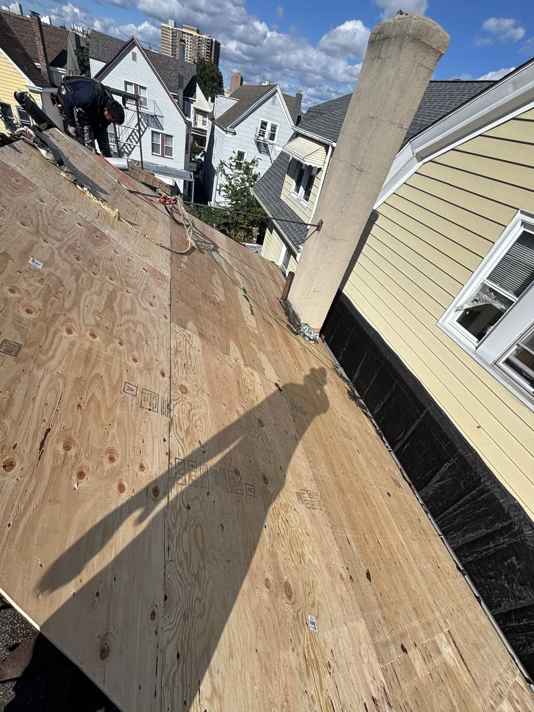 Old shingles stripped back in one section to reveal the original plank decking beneath.