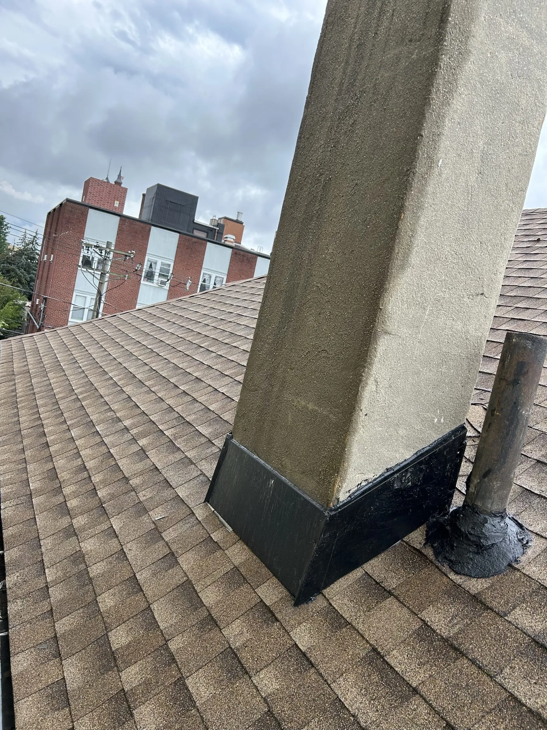 The same slope finished in new architectural shingles against the side wall and chimney.