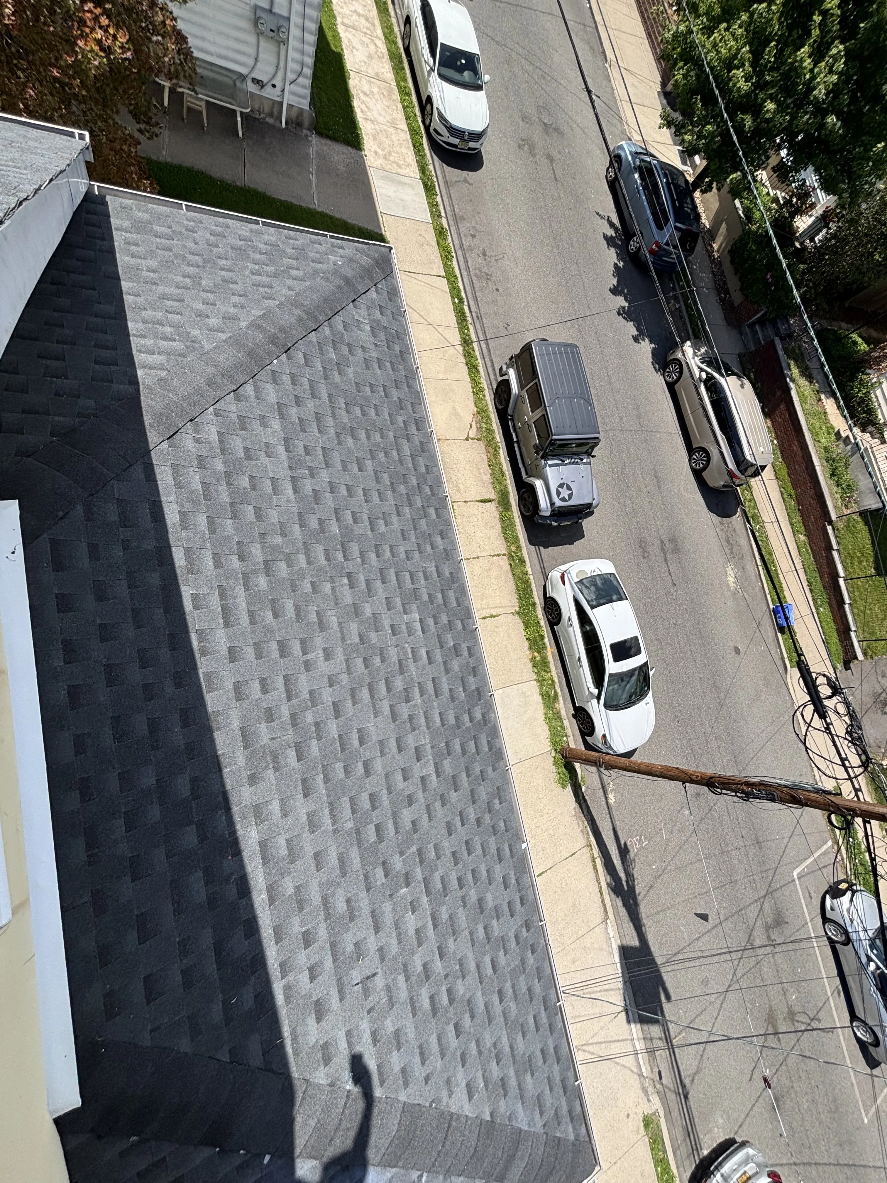 Finished charcoal shingle roof with tidy ridge and hip lines, overlooking the street below.