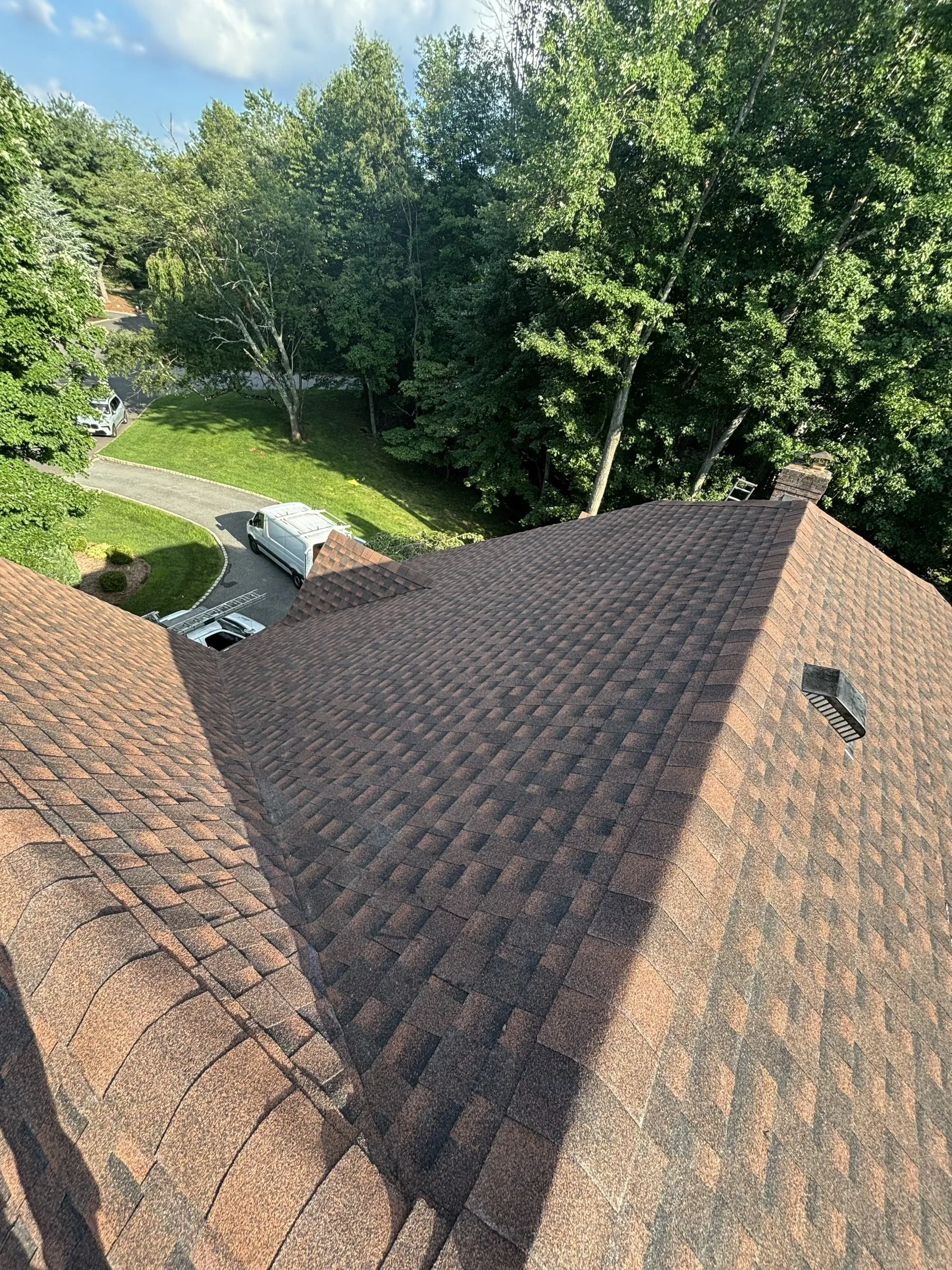 The completed roof planes falling away toward the driveway below.
