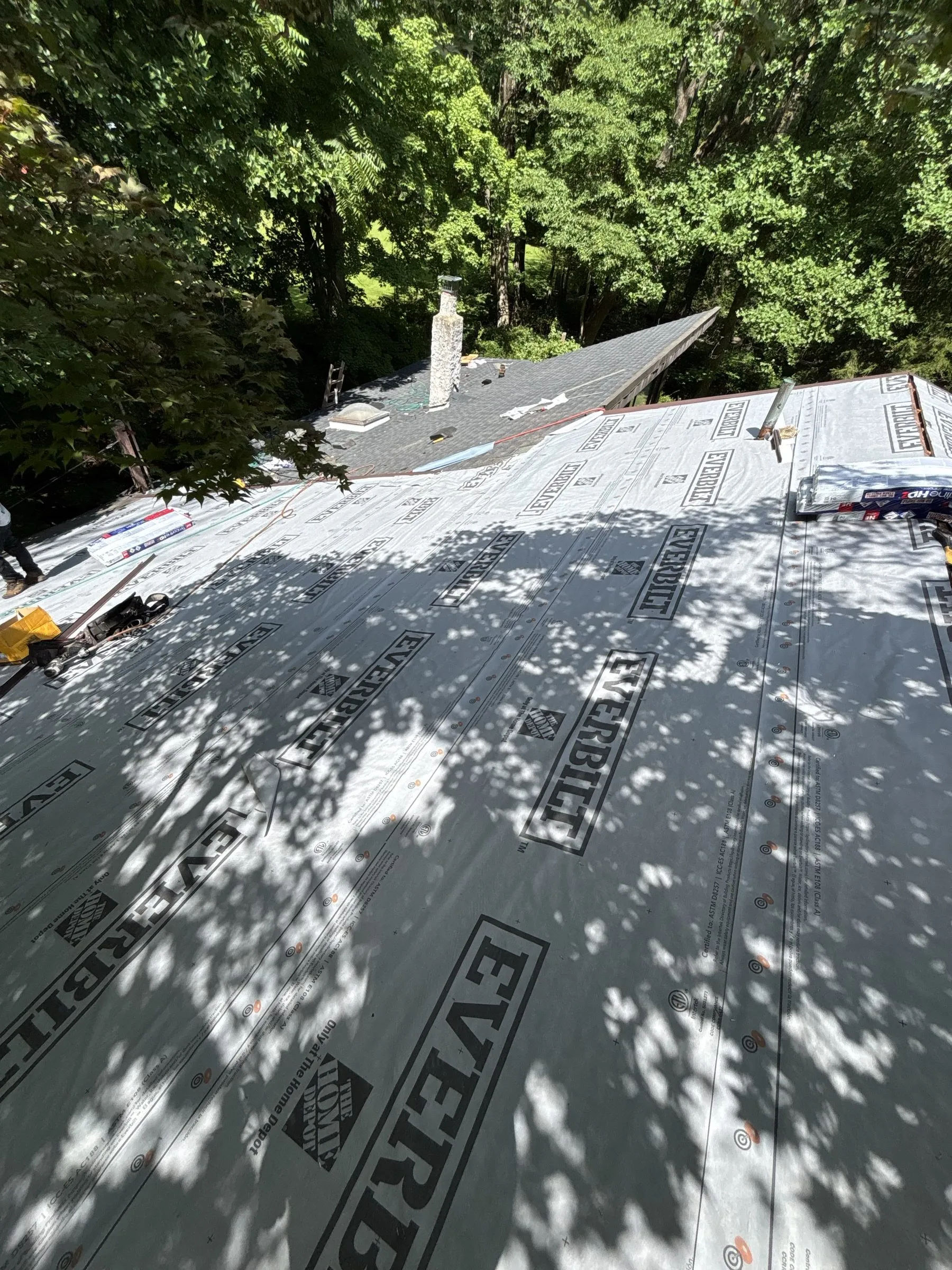 Synthetic underlayment run out over the deck with new metal drip edge along the eave.