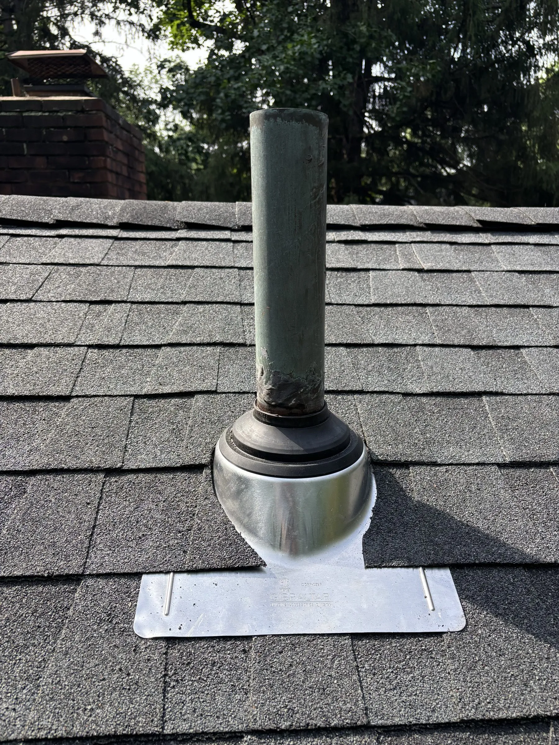 A new vent pipe collar flashed into the finished shingles.